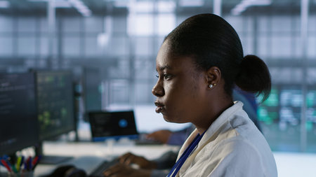 Close up of programmer in data center implementing AI predictive maintenance systems. Focus on IT professional in server hub using artificial intelligence to identify hardware failures, camera Aの写真素材