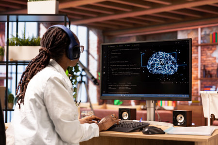 Software developer typing on PC keyboard, wearing headphones, using artificial intelligence...