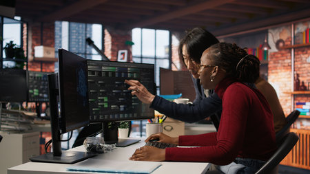 Exhausted AI startup employee rubbing forehead while analyzing datasets on computer, receiving...