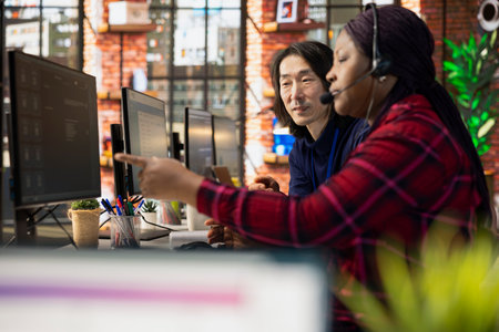 Team of multiethnic call center agents using AI to enhance customer interaction and resolve...