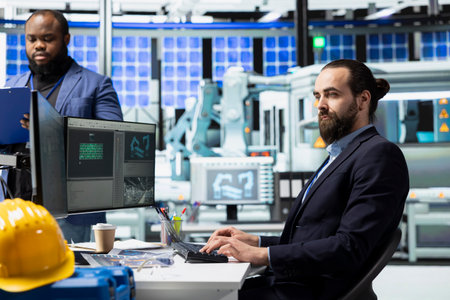 Male factory employee reviewing maintenance and systems in a solar panel plant, ensuring equipment...