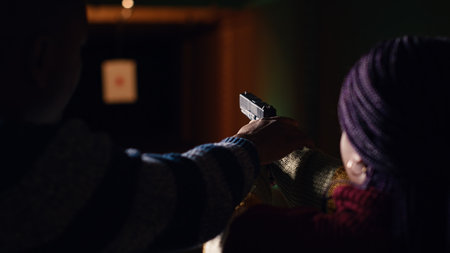 Shooting gallery worker teaching student how to hold pistol, close up. Firing range specialist providing guide to woman learning how to achieve high level of proficiency with firearms, camera Bの写真素材