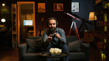 Excited man playing videogames using controller, having fun in neon illuminated room. Enthusiastic...