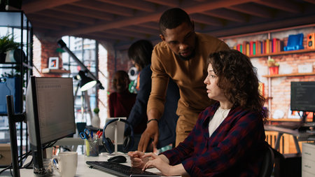 AI startup office chief technology officer overseeing woman building application. Manager assisting...