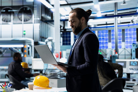 Industrial business analyst in suit inspecting renewable energy equipment, demonstrating attention...