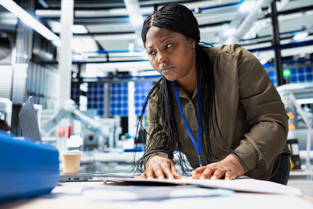 Black woman checking solar panel machinery and review checklist on files, playing a vital role in...