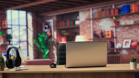 Empty modern apartment with a home office and a laptop on home office, trendy furniture in a loft with wooden floors and indoor plants. Stylish comfortable minimalist urban loft.の写真素材