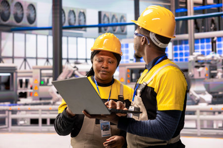 Industrial plant employees monitoring automated production line system. African american technicians...