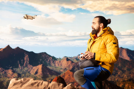 Content creator enjoying the fresh air and filming with his drone, recording professional video on...