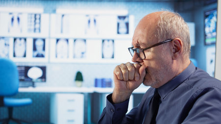 Specialist consulting patient with physical disability and a cough, discussing about treatment against respiratory discomfort. Medic helping senior man with advice, wheelchair user. Camera Aの写真素材