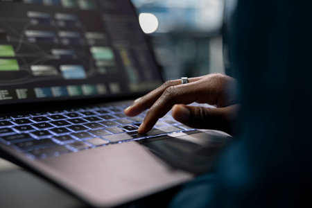 Close up of technician using laptop to do programming in server farm housing infrastructure storing...