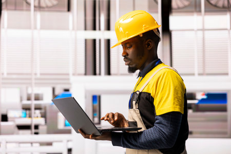 Industry 4.0 engineer programs robotic systems with digital software, optimizing automation line...