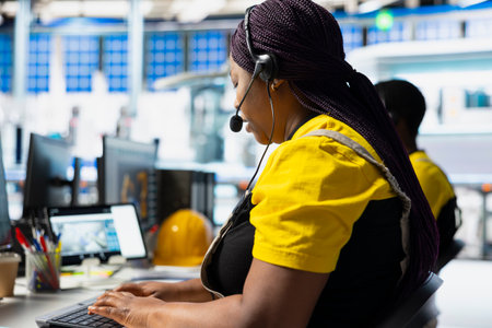 Factory technician offers assistance from solar panel call center, managing help line requests for support and troubleshooting. Customer service assistant improves operations.の写真素材