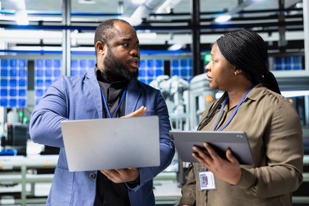 Technicians and business people examining solar panel units in a factory setting, reflecting teamwork, precision and insight in the industrial production of renewable energy. Sustainability.の写真素材