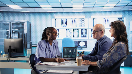 African american nurse evaluating lab test results and discussing recovery plan with senior couple,...