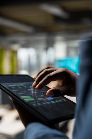 Close up of analyst focused on charts analysis on tablet to ensure expansion for IT company,...