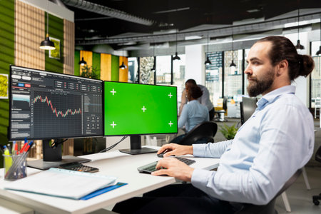 Day trader using software on green screen PC to capitalize on market fluctuations when buying and...