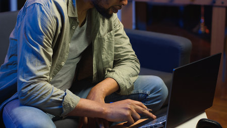 Black freelancer taking notes on textbook in order to solve his tasks, doing research and studying...