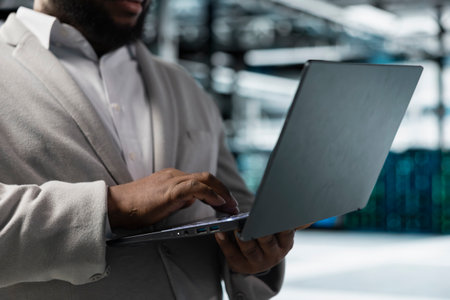 Close up of data center worker running error checking utilities on laptop, automating anomaly...