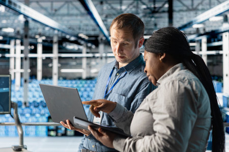 Team of data center admins using laptop to manage software updates for system stability. Teamworking...