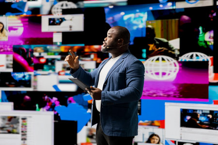 Black public speaker at a live convention engages the listeners with data on online trends, e commerce and communication using internet platforms. Real time social media visualization.の写真素材