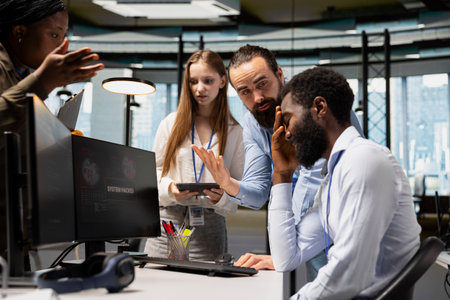 Team of admins collaborate to block hacking network intrusion affecting office equipment. IT expert...