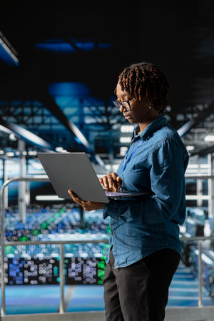 Portrait of black engineer working on data center industrial platform, completing software updates...