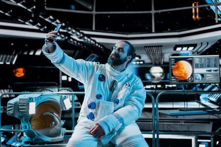 Astronaut filming with mobile phone camera, speaking with family, presenting space station....