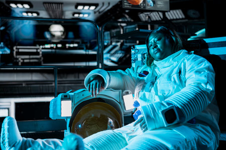 Astronaut lies still in cold spaceship chamber after temperature control failure causes severe heat loss. Crew member freezing in space station after conditions drop below survival limitの写真素材