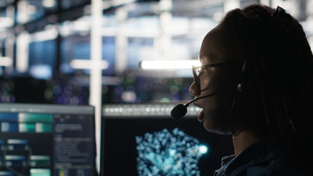 Data center employee uses audio headset and visual programming dashboard to troubleshoot client...
