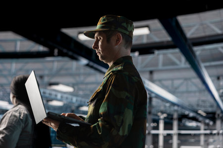 Army information technology expert in data center configuring encrypted servers to protect sensitive...