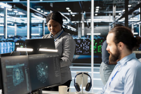 Engineers doing maintenance on blade servers supplying compute power for AI data processing and inference workloads. IT experts overseeing data center arrays managing training datasetsの写真素材