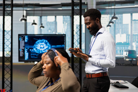 Computer scientist utilizing artificial intelligence to optimize performance using tablet. African...