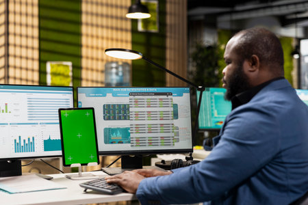 Professional manager works with graphs and isolated mockup screen, ensuring business success for the international market. Reviewing data for a global expansion strategy in office.の写真素材