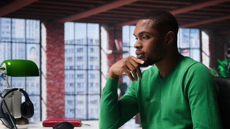 African american guy thinking about new ideas to increase clients numbers, multitasking to find a solution for financial growth. Young remote worker uses his creativity. Camera B.の写真素材
