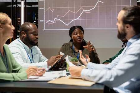African american supervisor discuss budgeting forecast with the team, sharing ideas and working on...