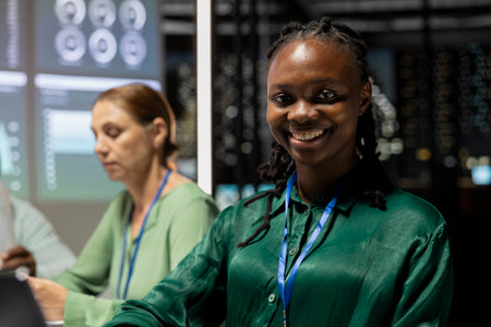 Smiling black executive assistant preparing a pitch for important meeting, increasing funds for development after hours. Coworkers team attend a discussion to address goal setting.の写真素材