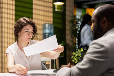 HR professional handing over the paper with job benefits package for candidate to review, checking the details of the contract. Company offering retirement plans and wellness programs.の写真素材