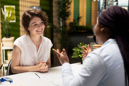Black female applicant signing the new employment contract during job interview, being accepted on the department team by the HR manager. Signature for paperwork agreement. New beginning.の写真素材