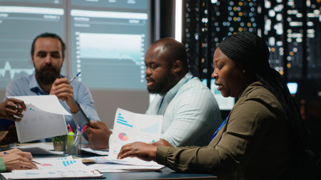 Team of colleagues attend an after hours business meeting for analysis on files, exchange...