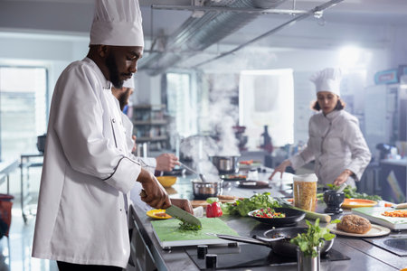 Focused professional chef minced fresh herbs for a new gourmet meal on the stove, cutting rosemary or thyme on the cutting board. Cook using fresh ingredients for a new tasty dish.の写真素材