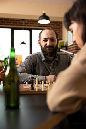 Portrait of smiling white man enjoying game of chess with friends. Caucasian male adult sitting at...