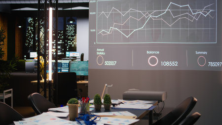 Empty corporate dark office with analytics tools on a projection screen, insights and infographics resources used for forecasting. Business strategy to drive efficiency after hours.の写真素材