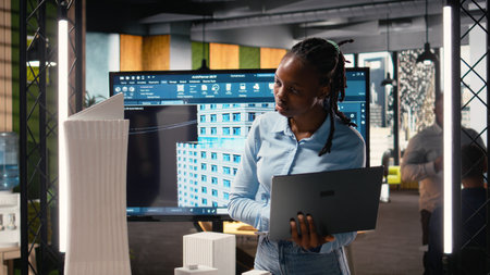 African american female evaluating 3D building model for measurements, creating construction...