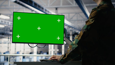 Army programmer in server hub uses AI application on green screen mockup PC to review reconnaissance information. Military data center worker uses AI on chroma key computer to plan mission, camera Bの写真素材