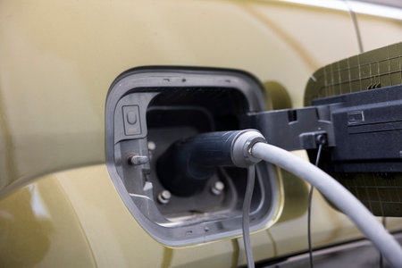 Close up of electric vehicle charging port flap opened to have battery powering electric motor charged. Vehicle inlet port of EV car opened to recharge battery by plugging into power sourceの写真素材
