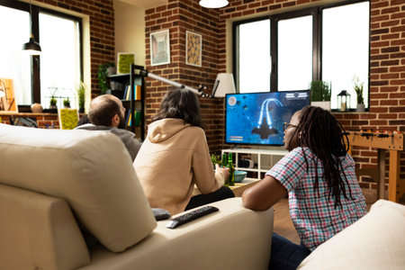Multiethnic group concentrate on interactive games displayed on tv screen during casual gathering....