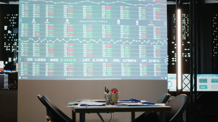 Empty office of corporation reveals a boardroom with forecast reports and digital graphs running on...