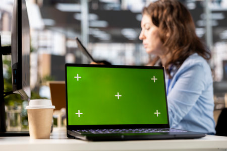 Young business advisor engages in task management next to chroma key, working on multinational company profit growth. Female manager focusing on strategy planning for success.の写真素材