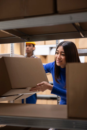Asian woman business owner preparing goods packed in the supply room, managing distribution for a...